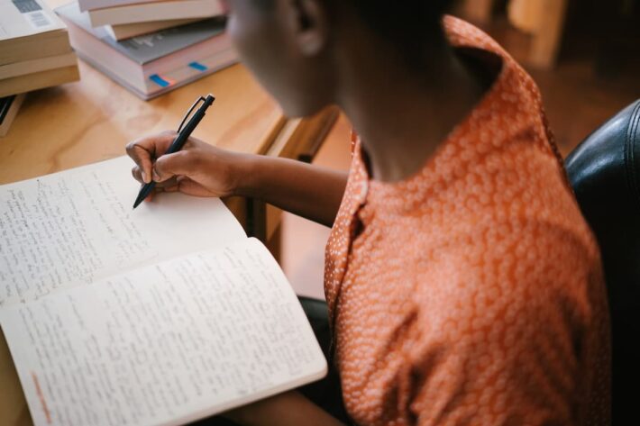 Mulher negra escrevendo livro